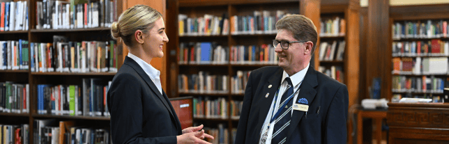 two colleagues talking in a library