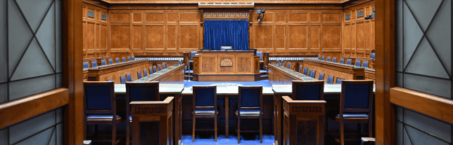 looking into the assembly chamber. A wood panelled room with blue chairs