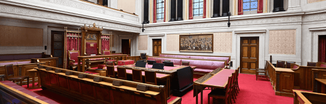 the senate chamber. Red carpeted room with wood desks and wooden chairs with red seats
